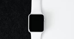 Une Apple Watch sur un fond moitié noir, moitié blanc.